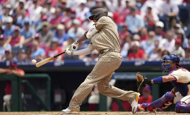 San Diego Padres' Manny Machado hits a three-run double against Philadelphia Phillies pitcher Mick Abel during the second inning in the first baseball game of a doubleheader Wednesday, July 2, 2025, in Philadelphia. (AP Photo/Matt Slocum)