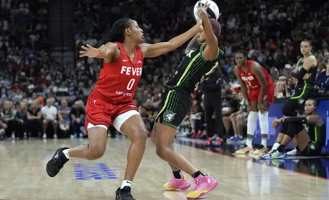 Minnesota Lynx guard Courtney Williams (10), right, handles the ball as Indiana Fever guard Kelsey Mitchell (0) defends during the first half of the WNBA Commissioner's Cup championship basketball game Tuesday, July 1, 2025, in Minneapolis. (AP Photo/Abbie Parr)