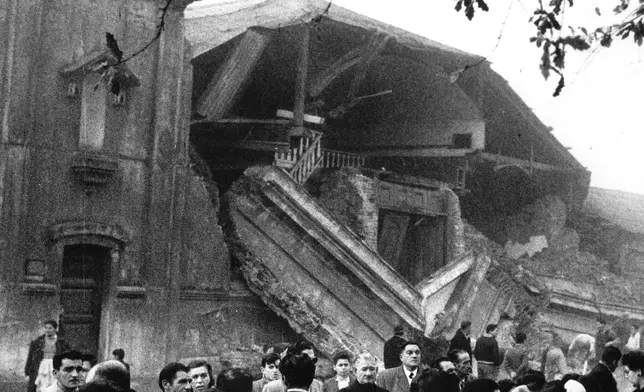 FILE - People in the foreground are looking at the ruins of Iglesia de Concepcion (Church of Concepcion) which partially collapsed as a result of the earthquake in Concepcion, Sunday, May 22, 1960. (AP Photo, File)