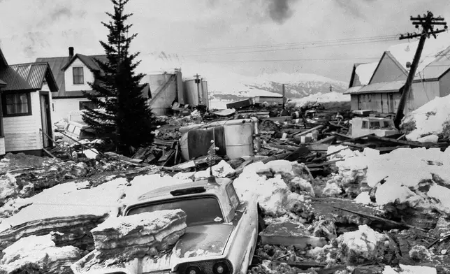 FILE -Where cars weren't buried, they were toss and damaged by huge slabs of ice pushed ashore by the tsunami following the major earthquake at Valdez, Alaska, which struck with deadly force, March 29, 1964. (AP Photo, File)