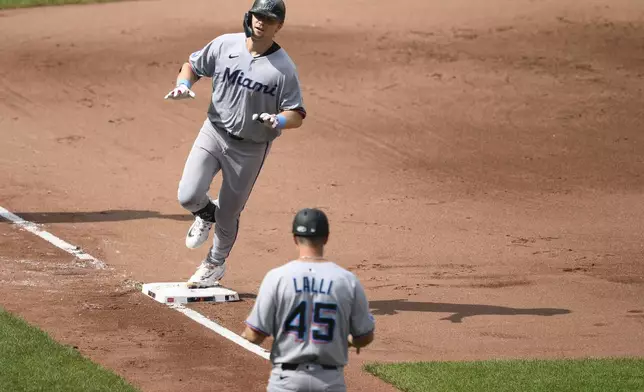 Miami Marlins' Kyle Stowers, top, celebrates after his two-run home run next to third base coach Blake Lalli (45) as he rounds the bases during the fifth inning of a baseball game against the Baltimore Orioles, Sunday, July 13, 2025, in Baltimore. (AP Photo/Nick Wass)