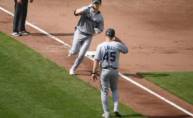 Miami Marlins' Kyle Stowers, center top, celebrates after his two-run home run with third base coach Blake Lalli (45) as he rounds the bases during the fifth inning of a baseball game against the Baltimore Orioles, Sunday, July 13, 2025, in Baltimore. (AP Photo/Nick Wass)