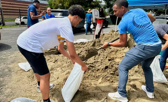 Volunteers fill sandbags for New Orleans residents, Wednesday, July 16, 2025, anticipating heavy rain from a tropical weather system moving toward the Gulf Coast. (AP Photo/Stephen Smith)