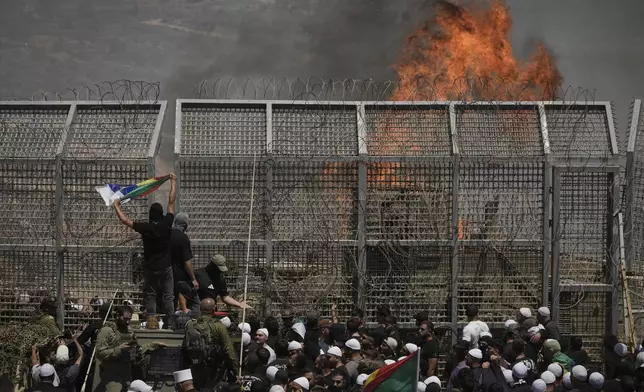 Druze from Syria and Israel protest on the Israeli-Syrian border, in Majdal Shams in the Israeli-controlled Golan Heights, Wednesday, July 16, 2025, amid the ongoing clashes between Syrian government forces and Druze armed groups in the southern Syrian city of Sweida. (AP Photo/Leo Correa)