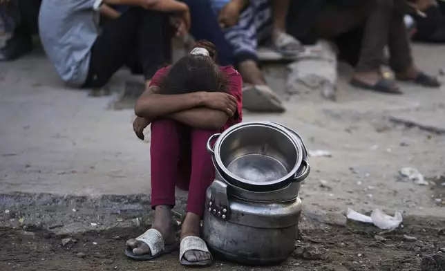 Palestinians wait for donated food at a community kitchen in Gaza City, in the northern Gaza Strip, Monday, July 14, 2025. (AP Photo/Jehad Alshrafi)