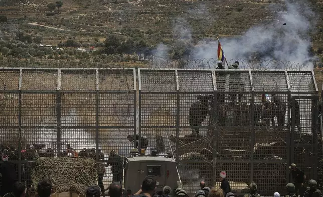 Syrian Druze protest near the Israeli-Syrian border, as seen from the town of Majdal Shams in the Israeli-controlled Golan Heights, Wednesday, July 16, 2025, amid the ongoing clashes between Syrian government forces and Druze armed groups in the southern Syrian city of Sweida. (AP Photo/Leo Correa)