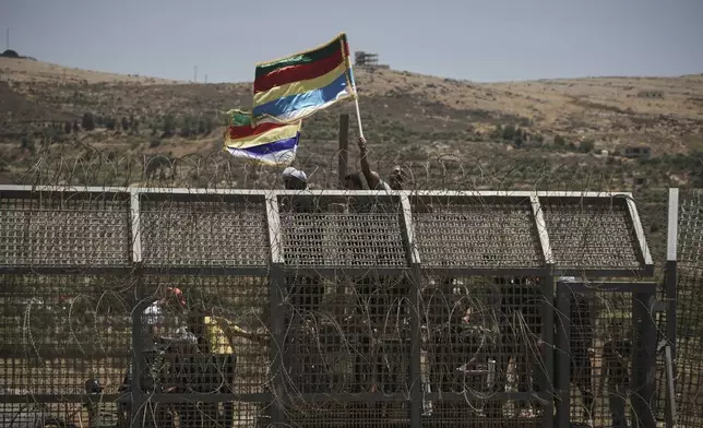 Syrian Druze protest near the Israeli-Syrian border, as seen from the town of Majdal Shams in the Israeli-controlled Golan Heights, Wednesday, July 16, 2025, amid the ongoing clashes between Syrian government forces and Druze armed groups in the southern Syrian city of Sweida. (AP Photo/Leo Correa)