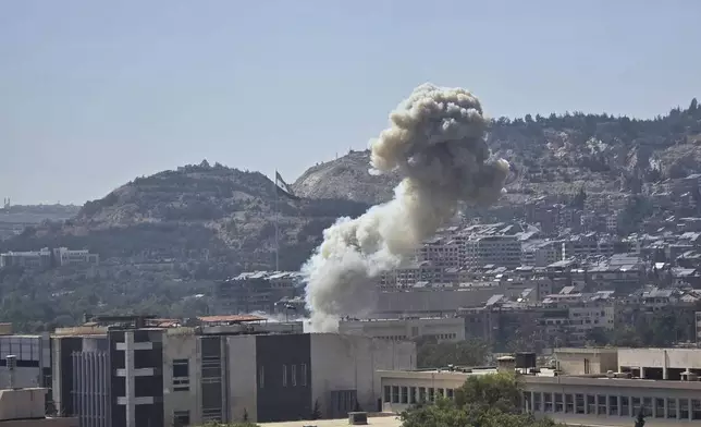 In this photo released by the Syrian official news agency SANA, smoke rises from an Israeli airstrike that hit the Syrian Defense Ministry in Damascus, Syria, Wednesday, July 16, 2025. (SANA via AP)