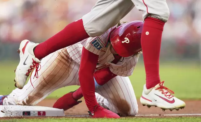Philadelphia Phillies' Bryson Stott steals third under Boston Red Sox third baseman Marcelo Mayer during the second inning of a baseball game Wednesday, July 23, 2025, in Philadelphia. (AP Photo/Matt Slocum)