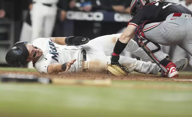 Miami Marlins' Connor Norby, left, is tagged out at the plate by Minnesota Twins catcher Ryan Jeffers, right, during the seventh inning of a baseball game, Wednesday, July 2, 2025, in Miami. (AP Photo/Lynne Sladky)