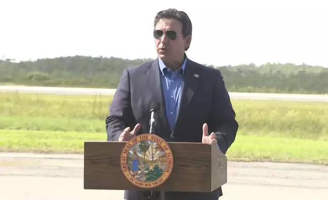 This image from a video feed shows Gov. Ron DeSantis speaking about deportation flights from the remote Everglades immigration lockup known as ”Alligator Alcatraz″ on July 25, 2025 in Ochopee, Florida. (AP Photo via Office Of Florida Governor Ron Desantis)