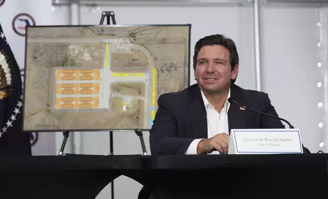 FILE - Gov. Ron DeSantis, R-Fla., listens during a roundtable at "Alligator Alcatraz," a new migrant detention facility at Dade-Collier Training and Transition facility, July 1, 2025, in Ochopee, Fla. (AP Photo/Evan Vucci, file)