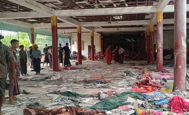 Buddhist monks and people check the debris inside a building in a Buddhist monastery that was allegedly hit by the military’s airstrike in Sagaing township in Sagaing region, Myanmar Friday, July 11, 2025. (UGC via AP)
