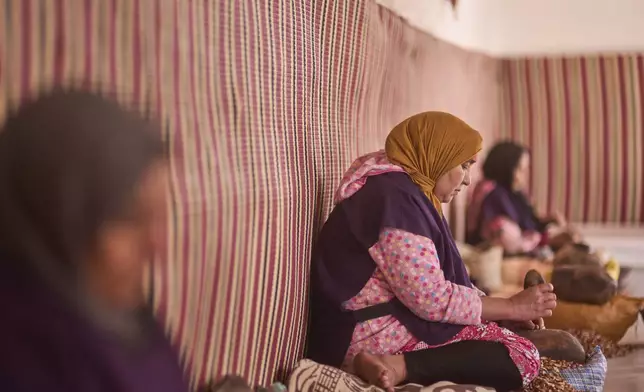 Women crack argan nuts at a cooperative that extracts and produces argan oil and products, in Essaouira, Morocco, Thursday, May 22, 2025. (AP Photo/Mosa'ab Elshamy)