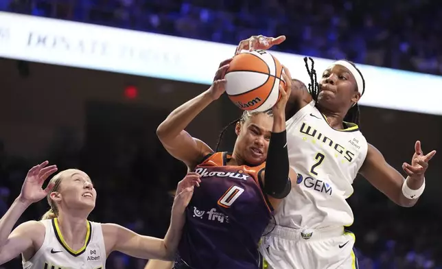 Phoenix Mercury's Satou Sabally (0) compete to control a rebound against Dallas Wings' Paige Bueckers, left, and Myisha Hines-Allen (2) in the first half of a WNBA basketball game Thursday, July 3, 2025, in Arlington, Texas. (AP Photo/Tony Gutierrez)
