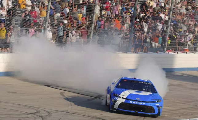 Denny Hamlin celebrates with a burnout after winning a NASCAR Cup Series auto race at Dover Motor Speedway, Sunday, July 20, 2025, in Dover, Del. (AP Photo/Derik Hamilton)
