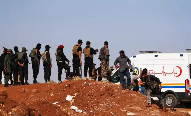A convoy of ambulances and buses arrives at a checkpoint in the village of Busra al-Harir, southern Syria, on its way to Sweida province, as security forces cordon off the area to block Bedouin fighters from entering the province, Tuesday, July 22, 2025. (AP Photo/Omar Sanadiki)