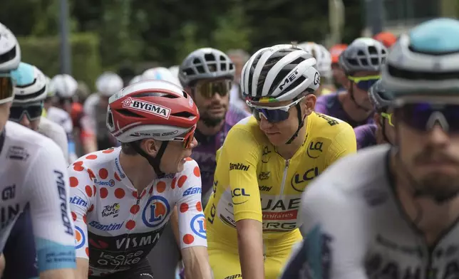 Slovenia's Tadej Pogacar, wearing the overall leader's yellow jersey, and Denmark's Jonas Vingegaard, wearing the best climber's dotted jersey, talking before the start of the twentieth stage of the Tour de France cycling race over 184.2 kilometers (114.5 miles) with start in Nantua and finish in Pontarlier, France, Saturday, July 26, 2025. (AP Photo/Thibault Camus)