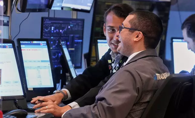 Traders Drew Cohen, foreground, and Dylan Halvorsan work on the floor of the New York Stock Exchange, Monday, July 21, 2025. (AP Photo/Richard Drew)