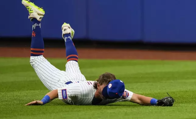 New York Mets outfielder Jeff McNeil dives to catch a ball during the eighth inning of a baseball game against the Cincinnati Reds, Saturday, July 19, 2025, in New York. (AP Photo/Yuki Iwamura)