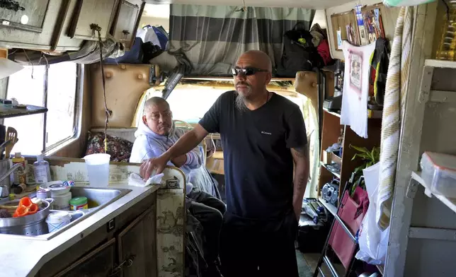 Carlos Perez stands inside an RV, where he lives with his brother, Selvin, left, in the Bayview neighborhood of San Francisco, Monday, July 14, 2025. (AP Photo/Terry Chea)