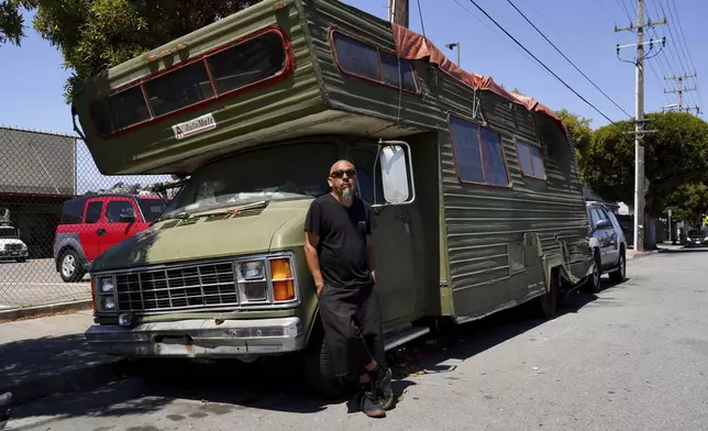 Carlos Perez poses for a photo outside his RV, where he lives, in the Bayview neighborhood of San Francisco, Monday, July 14, 2025. (AP Photo/Terry Chea)