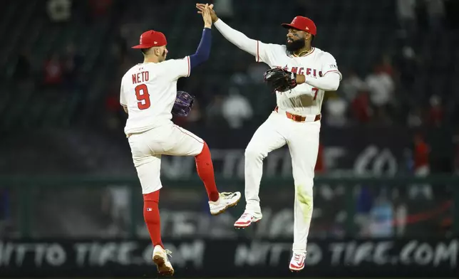 Los Angeles Angels' Jo Adell, right, and Zach Neto celebrate after winning a baseball game against the Texas Rangers Monday, July 28, 2025, in Anaheim, Calif. (AP Photo/William Liang)