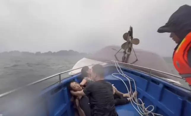 This image from a video provided by QDND shows people on a rescue boat after their tourist boat capsized in Ha Long Bay, Vietnam on Saturday, July 19, 2025. (QDND via AP)