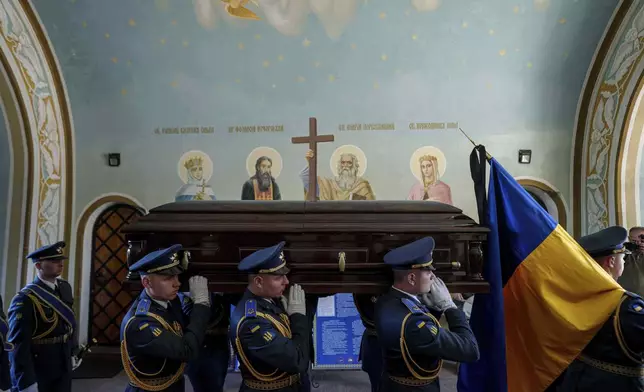 An honor guard carries the coffin of Ukrainian F-16 pilot Maksym Ustymenko, during a farewell ceremony in Kyiv, Ukraine, on Thursday, July 3, 2025. (AP Photo/Evgeniy Maloletka)