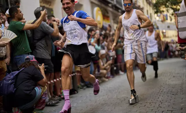Participants wearing shoes with heels of at least 15 centimeters (5.9 inches) compete in the annual high heel race during Madrid's Pride week, in Madrid, Spain, Thursday, July 3, 2025. (AP Photo/Manu Fernandez)