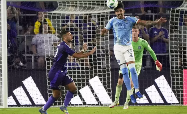 New York City FC defender Thiago Martins (13) clears the ball from his goal next to Orlando City midfielder Martin Ojeda, left, during the first half of an MLS soccer match, Wednesday, July 16, 2025, in Orlando, Fla. (AP Photo/John Raoux)