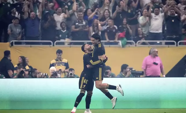 Mexico forward Alexis Vega, left, and Raúl Jiménez, right, celebrate Jimenez' goal against the United States in the first half of the CONCACAF Gold Cup final soccer match in Houston, Sunday, July 6, 2025. (AP Photo/Ashley Landis)