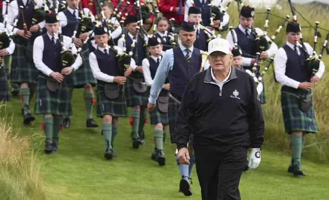 President Donald Trump arrives, followed by a bagpiper band, at the opening ceremony for the Trump International Golf Links golf course, near Aberdeen, Scotland, Tuesday, July 29, 2025. (AP Photo/Jacquelyn Martin)