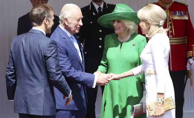 Britain's King Charles III and Queen Camilla welcome France's President Emmanuel Macron, left, and his wife Brigitte Macron, right, in Windsor, England, Tuesday July 8, 2025, on the first day of a three-day state visit to Britain. (Chris Jackson/Pool via AP)