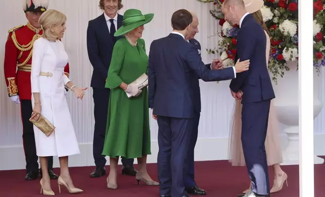 Britain's King Charles III, 3rd right, Queen Camilla, center left, Prince William, second right, and Kate, Princess of Wales, right, welcome France's President Emmanuel Macron, 4th right, and his wife Brigitte Macron, left, in Windsor, England, Tuesday July 8, 2025, on the first day of a three-day state visit to Britain. (Chris Jackson/Pool via AP)