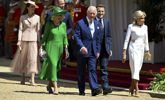 Britain's King Charles III, 3rd right, Queen Camilla, Prince William 3rd left, and Kate, Princess of Wales, left, walk with French President Emmanuel Macron, second right, and his wife Brigitte Macron, right, during a welcome ceremony, in Windsor, England, Tuesday July 8, 2025, on the first day of a three-day state visit to Britain. (Dylan Martinez/Pool via AP)