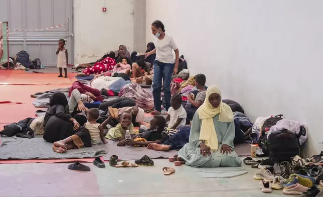 A woman prays as migrants from Africa rest in Agia port, Chania, Crete island, Greece, Monday, July 7, 2025. (AP Photo/Giannis Angelakis)