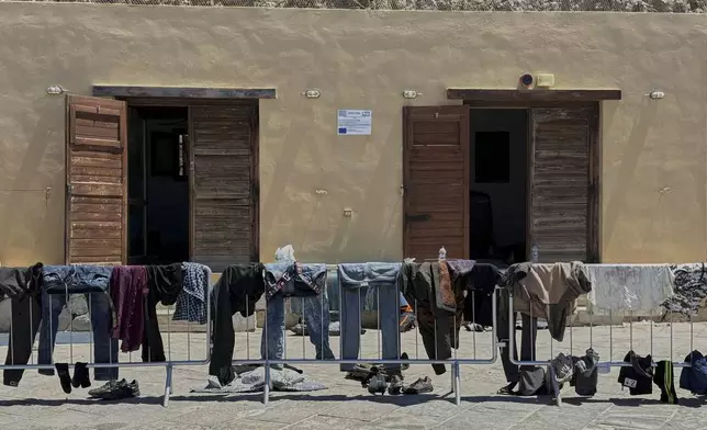Clothes belonging to migrants and refugees who crossed the Mediterranean Sea from Libya to Greece hang on an iron fence to dry at Karave port on the island of Gavdos, Greece, on Monday, July 7, 2025. (AP Photo/Elena Becatoros)
