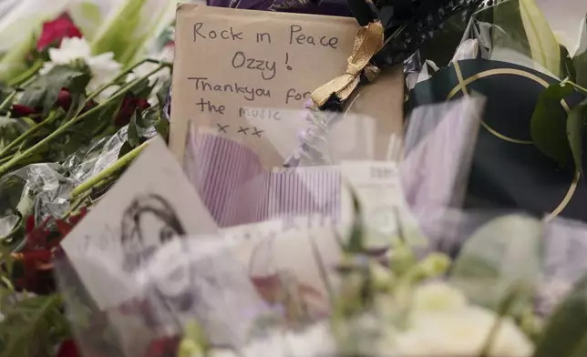 Tributes left to honour musician Ozzy Osbourne as thousands of fans gathered to watch a funeral procession for Black Sabbath frontman Ozzy Osbourne following his death aged 76, in Birmingham, England, Wednesday, July 30, 2025. (AP Photo/Alberto Pezzali)