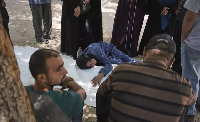 The mother of Raafat Al-Rubaie mourns over his body at a clinic in Gaza City on Sunday, July 20, 2025, after he was killed while attempting to reach aid trucks entering northern Gaza through the Zikim crossing from Israel. (AP Photo/Jehad Alshrafi)