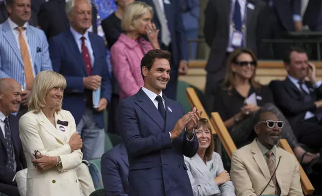 Tennis legend Roger Federer applauds after Serbia's Novak Djokovic beat Australia's Alex de Minaur during a fourth round men's singles match at the Wimbledon Tennis Championships in London, Monday, July 7, 2025. (AP Photo/Kin Cheung)