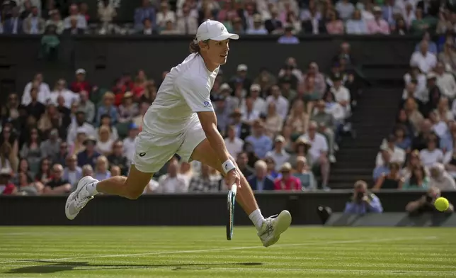 Australia's Alex de Minaur returns to Serbia's Novak Djokovic during a fourth round men's singles match at the Wimbledon Tennis Championships in London, Monday, July 7, 2025. (AP Photo/Kin Cheung)