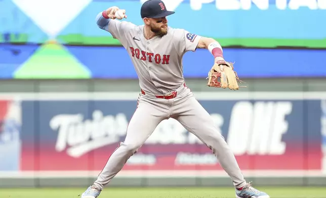Boston Red Sox shortstop Trevor Story throws to first base to get out Minnesota Twins' Ty France during the second inning of baseball game Tuesday, July 29, 2025, in Minneapolis. (AP Photo/Matt Krohn)