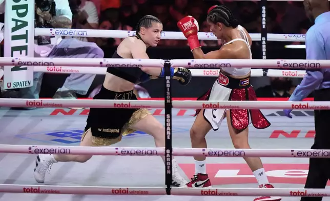 Ireland's Katie Taylor, left, punches Puerto Rico's Amanda Serrano during the first round of a super lightweight championship boxing match Friday, July 11, 2025, in New York. (AP Photo/Frank Franklin II)