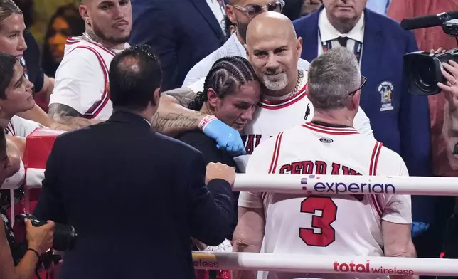 Puerto Rico's Amanda Serrano is comforted by her team after losing to Ireland's Katie Taylor after a super lightweight championship boxing match Saturday, July 12, 2025, in New York. (AP Photo/Frank Franklin II)