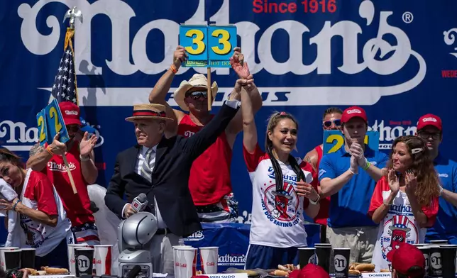 Competitive eater Miki Sudo, center, celebrates after finishing 1st during the 2025 Nathan's Famous Fourth of July hot dog eating contest in the Coney Island section of the Brooklyn borough of New York, Thursday, July 4, 2025. (AP Photo/Yuki Iwamura)