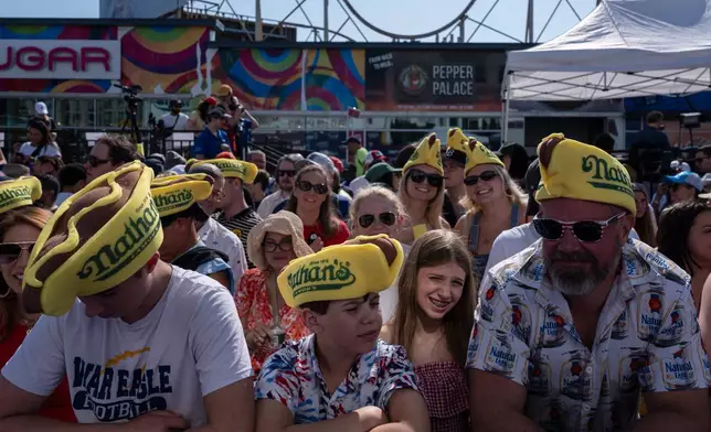 People wait for the 2025 Nathan's Famous Fourth of July hot dog eating contest in the Coney Island section of the Brooklyn borough of New York, Thursday, July 4, 2025. (AP Photo/Yuki Iwamura)