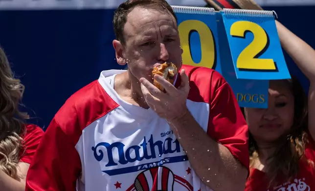 Competitive eater Joey Chestnut eats hot dogs during the 2025 Nathan's Famous Fourth of July hot dog eating contest in the Coney Island section of the Brooklyn borough of New York, Thursday, July 4, 2025. (AP Photo/Yuki Iwamura)
