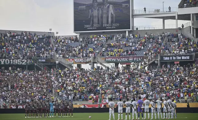 Players stand during a minute of silence for two soccer players who were killed in a car crash, Diogo Jota and his brother Andre Silva, before the Club World Cup quarterfinal soccer match between Fluminense and Al Hilal in Orlando, Fla., Friday, July 4, 2025. (AP Photo/Phelan M. Ebenhack)