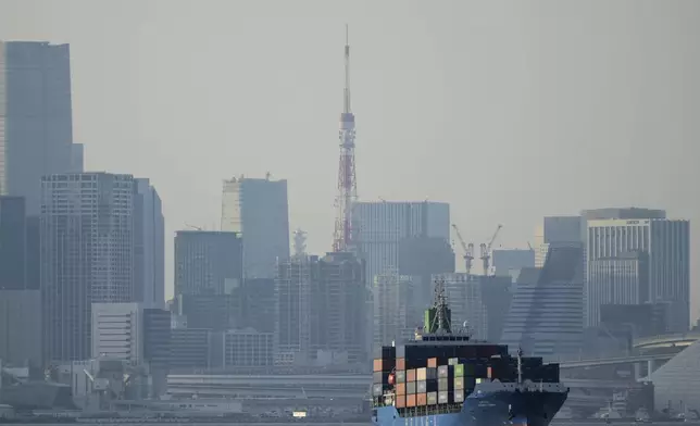 FILE - Tokyo Tower is seen amid tall buildings as a container ship leaves a cargo terminal in Tokyo, April 9, 2025. (AP Photo/Hiro Komae, File)